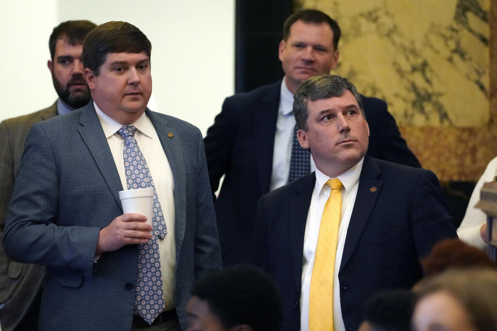 Republican Sens. Jeremy England, R-Vancleave, left, and Daniel Sparks of Belmont, listen as the Senate Clerk tallies the vote on a bill that would place new restrictions on car manufacturers for opening brick-and-mortar car dealerships, following a long floor debate in the Chamber at the Mississippi Capitol in Jackson, Thursday, March 2, 2023. The bill, which passed, sparked an intraparty debate among Republican lawmakers, with opponents arguing it would stop electric car makers from bringing new technology and jobs to the state. (AP Photo/Rogelio V. Solis)