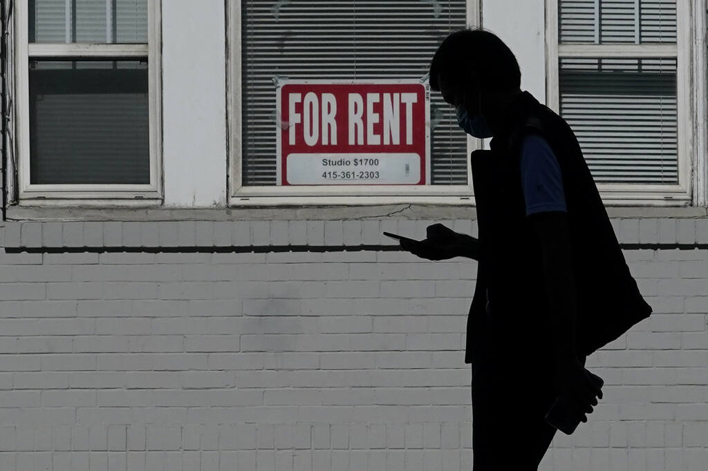 A man walks in front of a For Rent sign in a window of a residential property in San Francisco, Tuesday, Oct. 20, 2020. (AP Photo/Jeff Chiu)