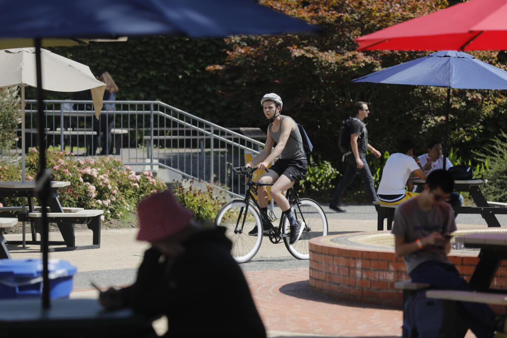 Logan Warren rides his bicycle to a statistics class during the first day at Santa Rosa Junior College in Santa Rosa, Calif. on Monday, August 15, 2022. (Beth Schlanker/The Press Democrat)