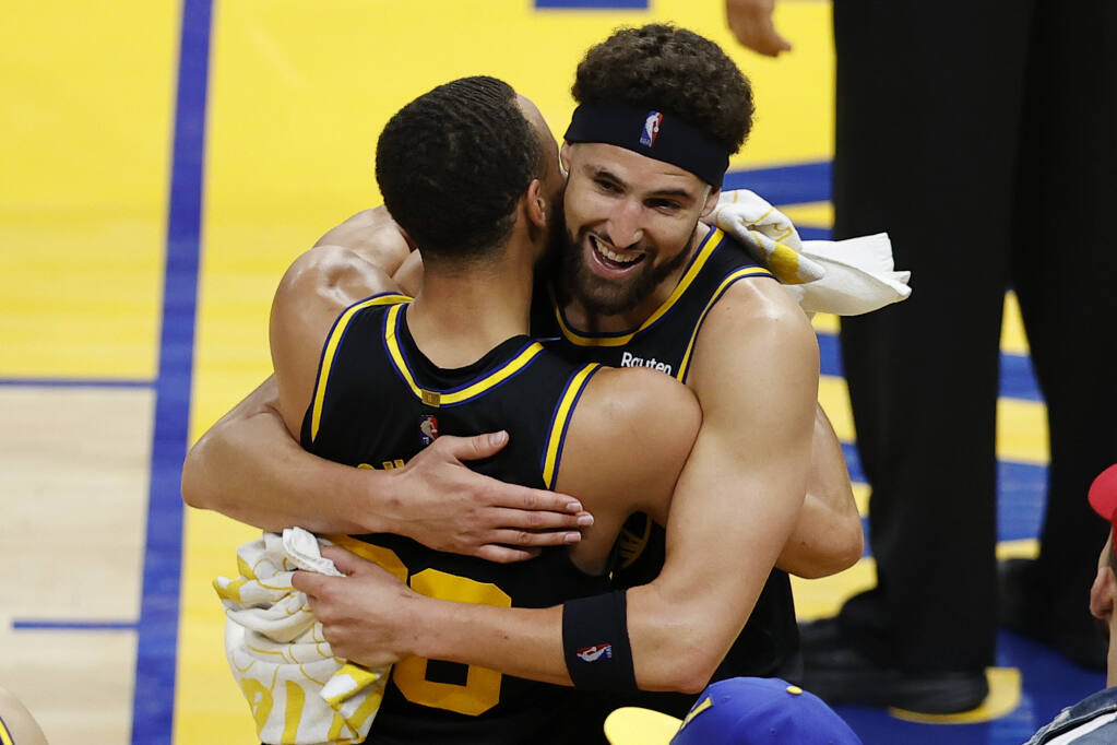 Warriors guard Klay Thompson, right, hugs Stephen Curry after deafeating the Dallas Mavericks in Game 5 of the Western Conference Finals in San Francisco on Thursday, May 26, 2022, to advance to the NBA Finals. (John Hefti / ASSOCIATED PRESS)