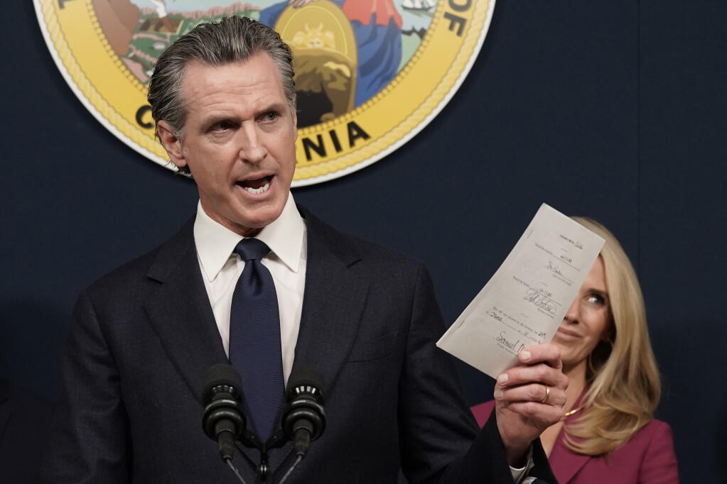 FILE — California Gov. Gavin Newsom displays a bill he signed that shields abortion providers and volunteers in California from civil judgments from out-of-state courts during a news conference in Sacramento, Calif., June 24, 2022. (AP Photo/Rich Pedroncelli, File)