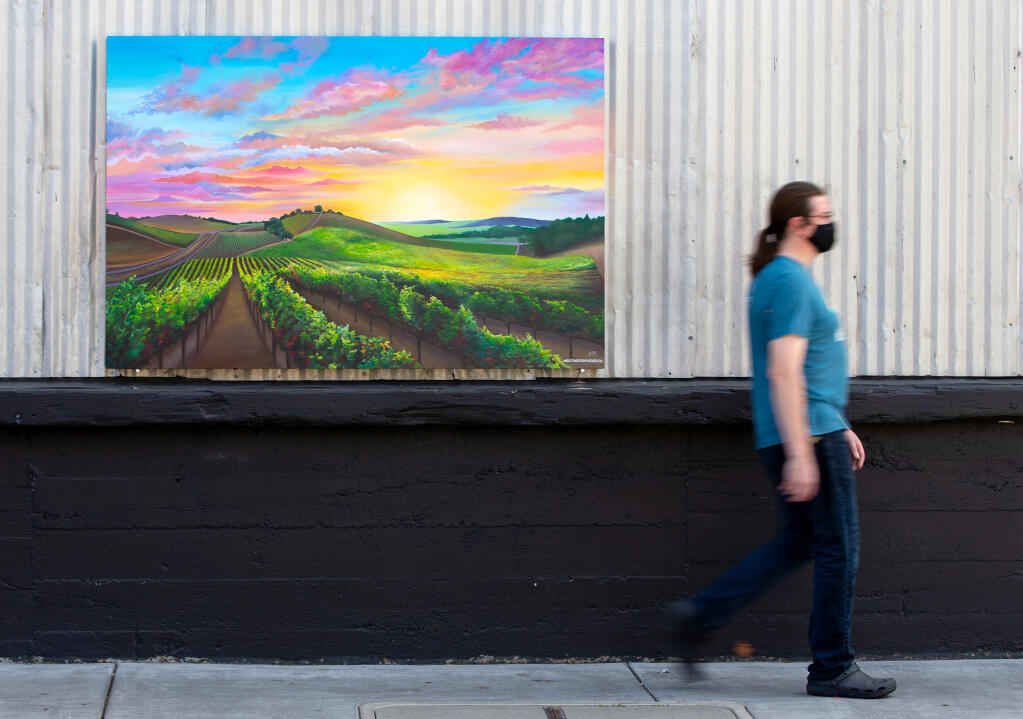 A pedestrian walks past a mural by artist Audrey Maddigan-Martin, one of seven paintings from various artists that make up the new public art showcase: "Greetings from The Barlow: A Postcard Tribute to Sonoma County," at The Barlow in Sebastopol, California, on Wednesday, September 16, 2020. (Alvin A.H. Jornada / The Press Democrat)