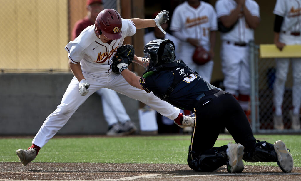 Cody Guy of Cardinal Newman is tagged out at the plate by Ukiah High School catcher Canyon Loflin on Friday, April 22, 2022 at Cardinal Newman High School in Santa Rosa. (Kent Porter / The Press Democrat)