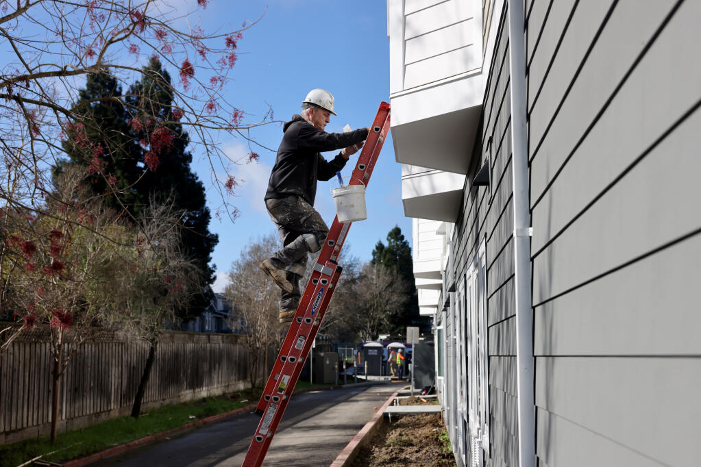 Joe Lepori of Mike’s Painting works on the exterior trim work of Heritage House, a 66-unit affordable housing project by Burbank Housing, in Napa, Thursday, Jan. 25, 2024. (Beth Schlanker / The Press Democrat)