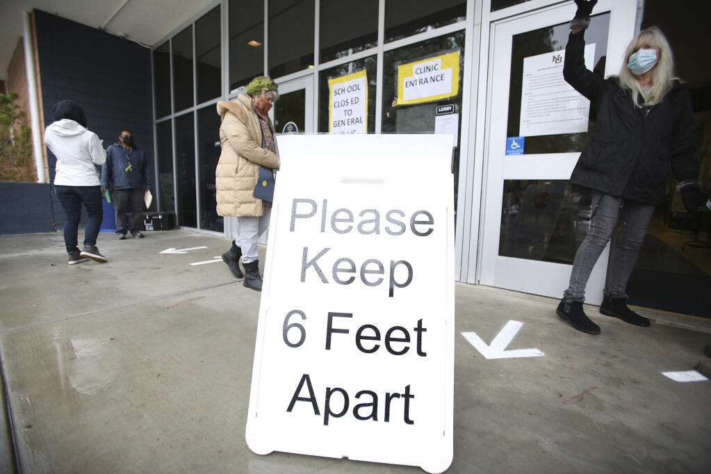 FILE - A sign asks those getting vaccinated to keep 6 feet apart during the vaccination event, Wednesday, Jan. 27, 2021, at Nevada Union High School in Grass Valley, Calif. (Elias Funez/The Union via AP, File)