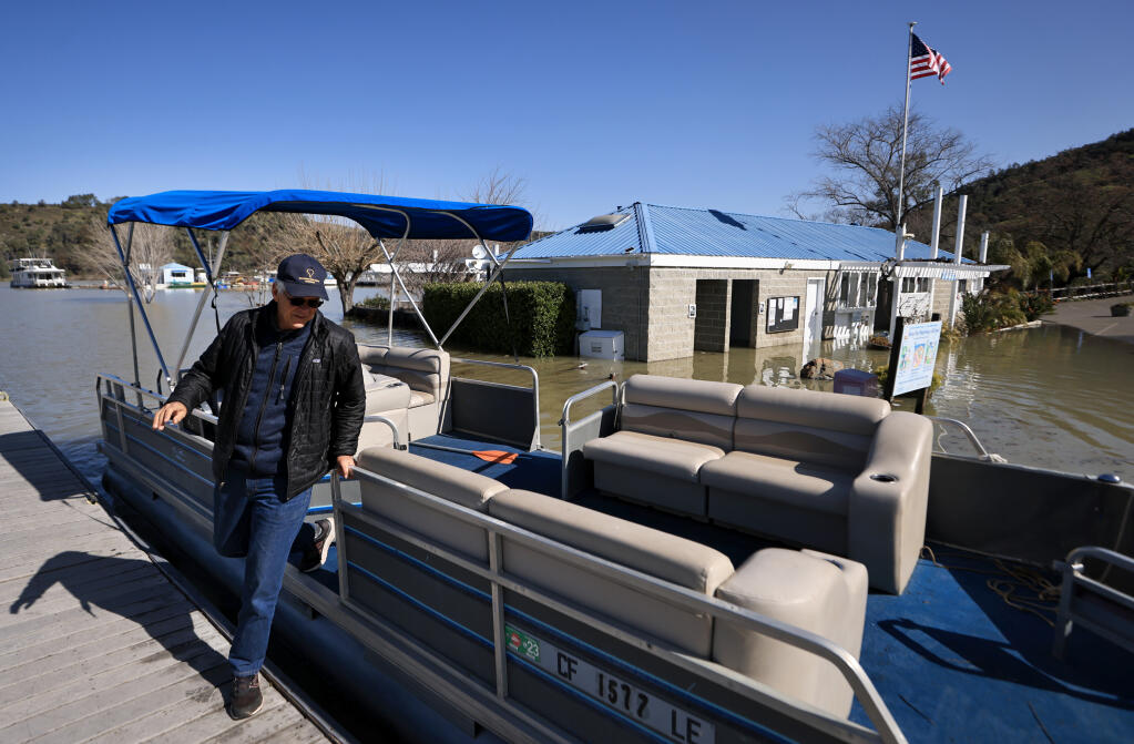 Because the water is so deep at Lake Sonoma, managers of the private marina left a pontoon boat for individuals like Andy Finfrock of Santa Rosa, to check on their own boat moored in one of the slips that is not accessible by foot. Wednesday, March 15, 2023. (Kent Porter / The Press Democrat) 2023