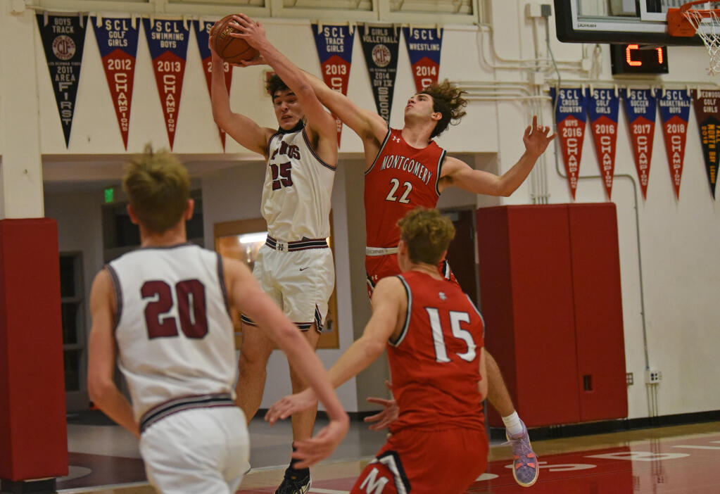 Graham MacDonald of Healdsburg High fighting for the ball against Nolan Bessire, right, of Montgomery High during their North Bay League Oak game held in Healdsburg, Calif. on Wednesday, Jan. 19, 2022. (Erik Castro / for The Press Democrat)