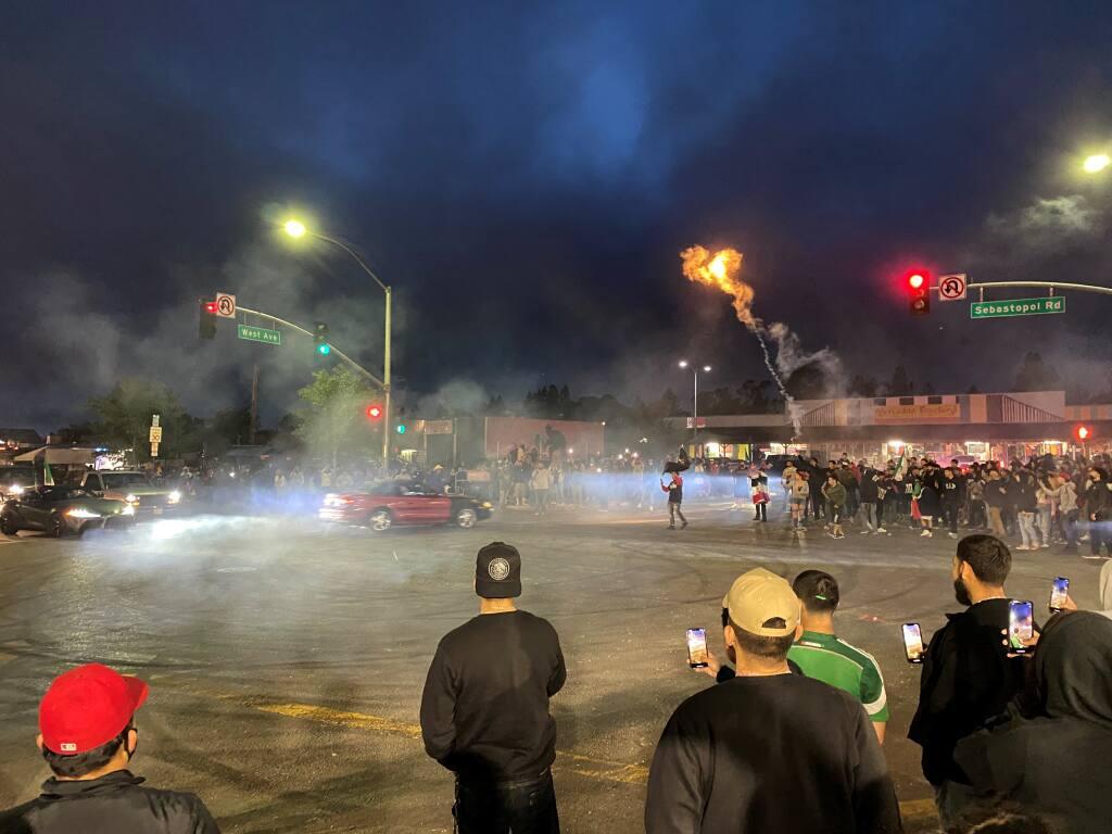 A crowd of several hundred people attend a sideshow at Sebastopol Road and West Avenue on Wednesday, May 5, 2021. (Kent Porter / The Press Democrat)
