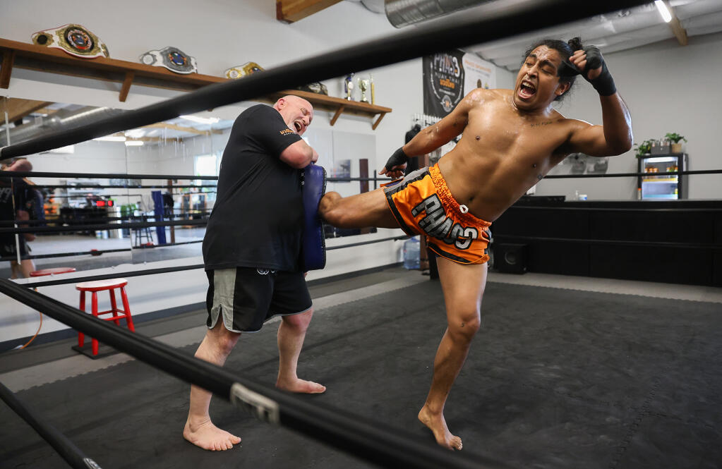 Fighter Robbinson Galvez, right, practices kicks with coach Ben Brown, head trainer and owner of Santa Rosa’s Phas3 Martial Arts, during a training session earlier this month. (Christopher Chung / The Press Democrat)