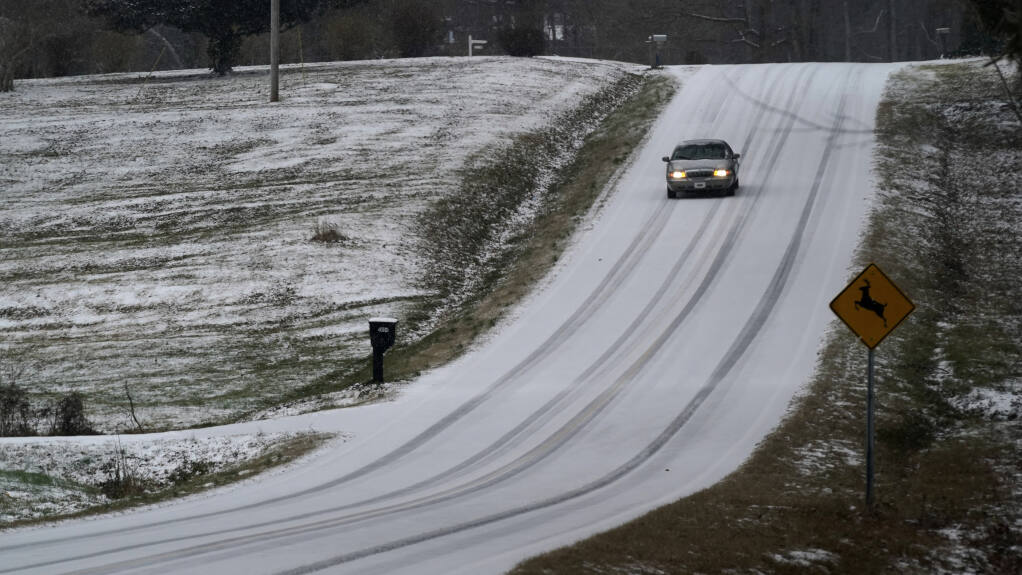 A driver navigates an icy road as a winter storm moves through the area in Orange County near Hillsborough, N.C., Sunday, Jan. 16, 2022. (AP Photo/Gerry Broome)