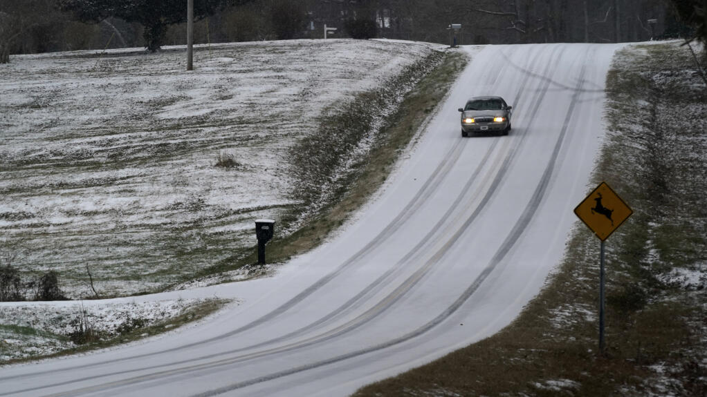 A driver navigates an icy road as a winter storm moves through the area in Orange County near Hillsborough, N.C., Sunday, Jan. 16, 2022. (AP Photo/Gerry Broome)