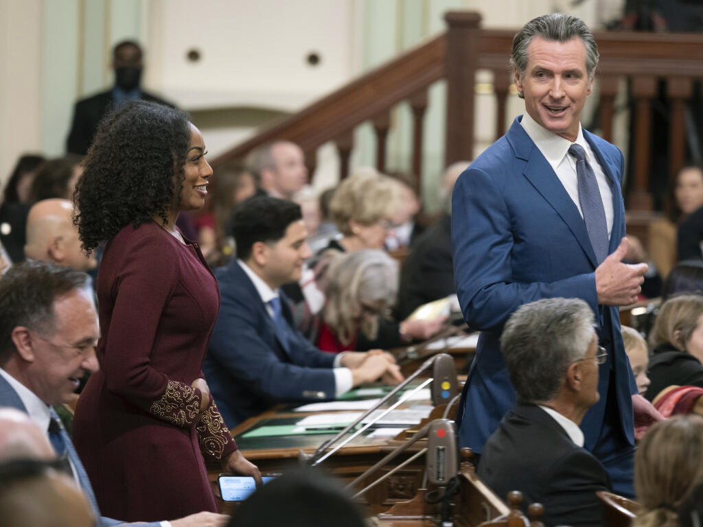 California Gov. Gavin Newsom walks through the assembly chamber with California Controller Malia Cohen during the opening session of the California Legislature in Sacramento, Calif., Monday, Dec. 5, 2022. The legislature returned to work on Monday to swear in new members and elect leaders for the upcoming session. (AP Photo/José Luis Villegas, Pool)