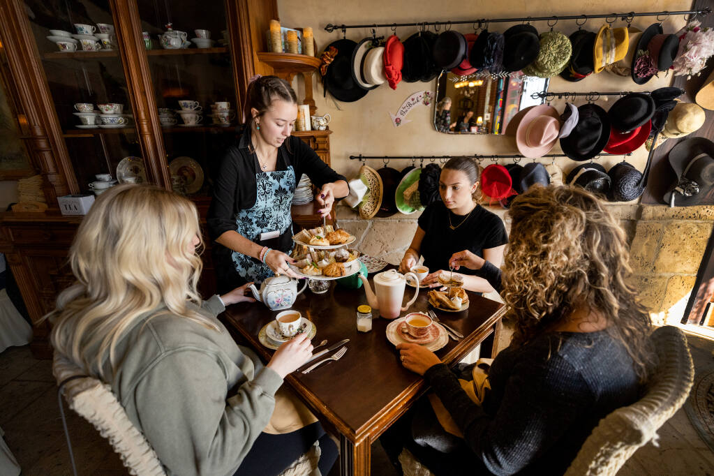 Savannah McGovern brings out sampling of scones and triangle sandwiches at the Tudor Rose English Tea Room in Santa Rosa on Friday, Nov. 18, 2022. The downtown business will close after 10 years.  (John Burgess / The Press Democrat)