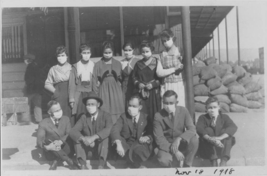 Office staff of the George P. McNear Feed Company wear face masks as they gather outside their Petaluma building during the 1918 flu pandemic. (Sonoma County Library)