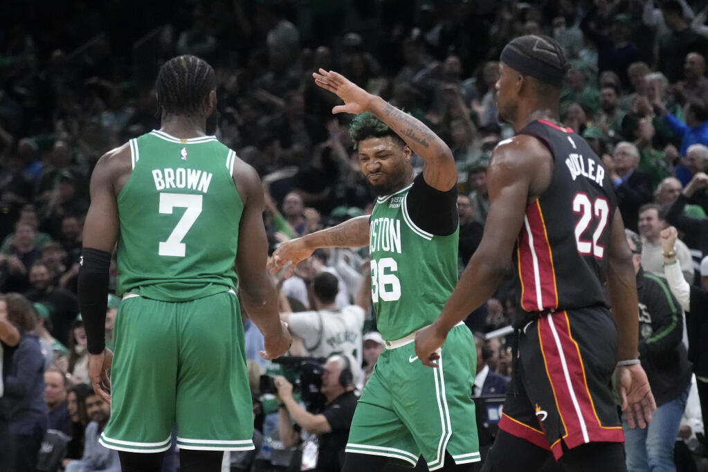 Celtics guard Jaylen Brown, left, and guard Marcus Smart, center, celebrate as Miami Heat forward Jimmy Butler walks by during the first half in Game 5 of the Eastern Conference finals Thursday, May 25, 2023, in Boston. (Charles Krupa / ASSOCIATED PRESS)