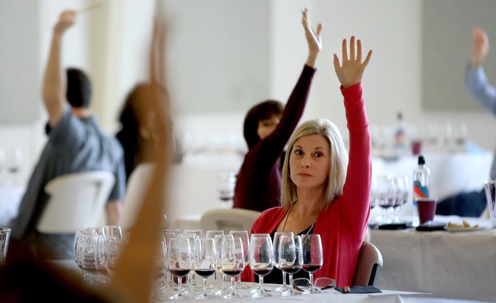 Judges for the North Coast Wine Challenge raise their hands as they vote for their favorite varietal, Wednesday, July 15, 2020 at the Sonoma Count Fairgrounds in Santa Rosa. (Kent Porter / The Press Democrat) 2020