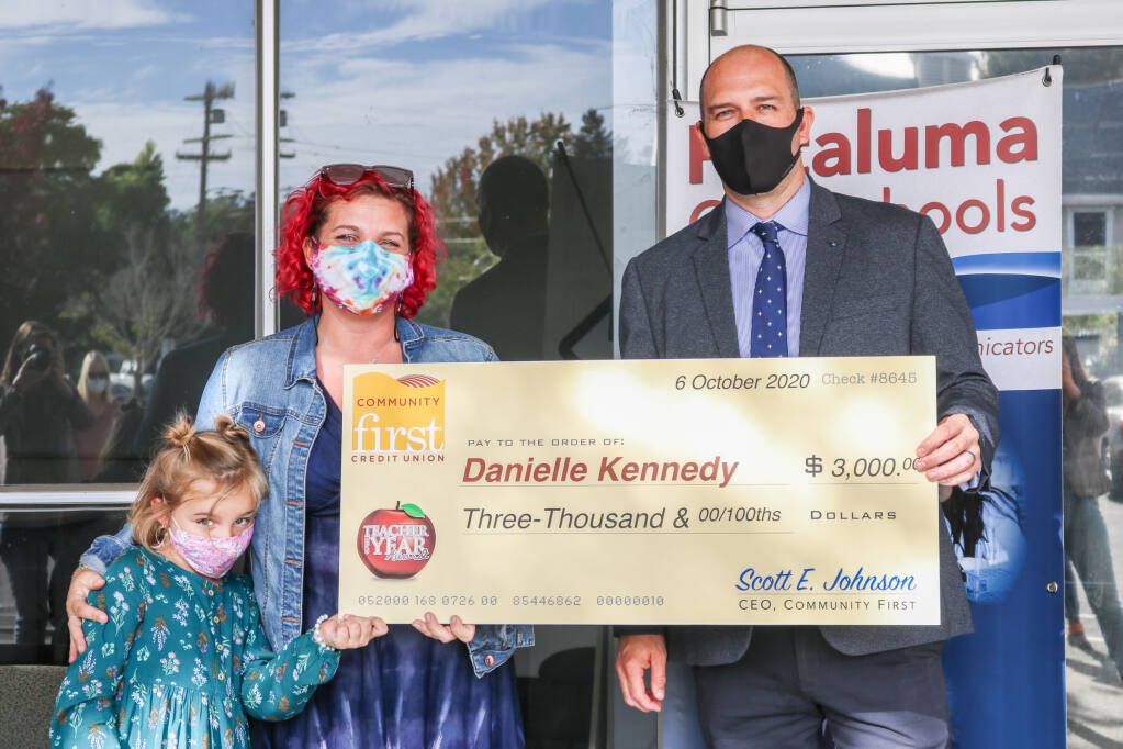 Danielle Kennedy and her daughter pose with Matthew Harris, superintendent of Petaluma City Schools, during a ceremony recognizing Kennedy as Sonoma County's 2022 Teacher of the Year. As part of the recognition, Kennedy was awarded $3,000 from Community First Credit Union. (Petaluma City Schools)