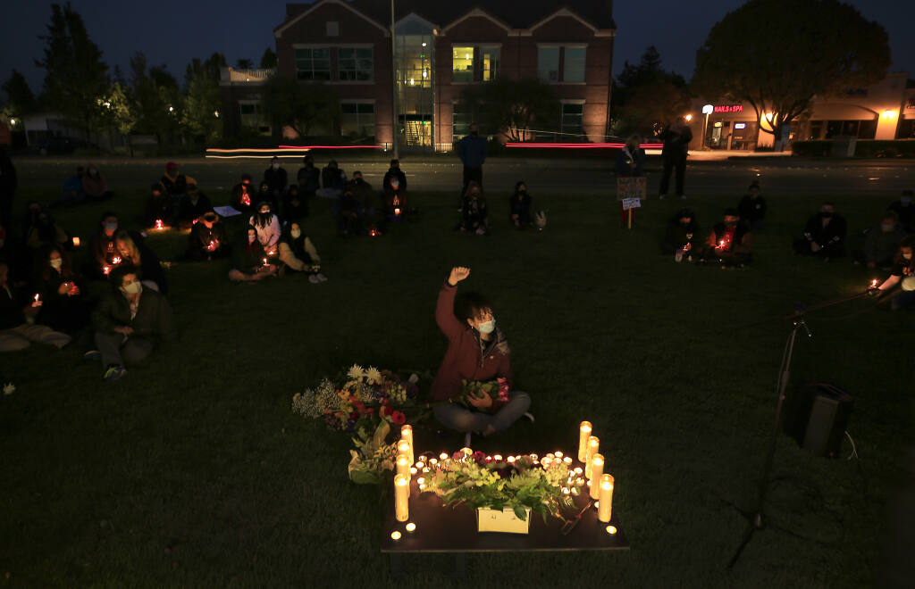 Amber Lucas, middle, joins over 100 people for a Black Lives Matter candlelight vigil, In front of Santa Rosa Junior College in Santa Rosa, Friday, April 16, 2021, in response to the police shooting death of Daunte Wright in Minnesota.  (Kent Porter / The Press Democrat) 2021