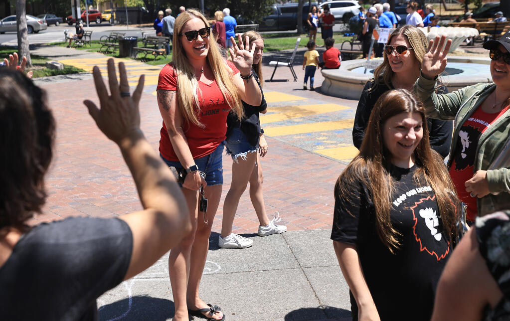 Gillian Hayes, in red, Leslie McCormick, Jessalee Mills and Tasha Mattison, front right, say their goodbyes after they spoke about the consolidation of Analy and El Molino High Schools and impending lawsuit, to attendees of a rally at the Sebastopol Town Square, Saturday, July 17, 2021. (Kent Porter / The Press Democrat)