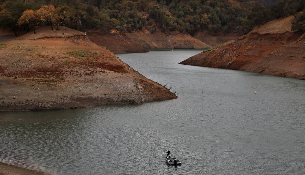 Adjacent to the private marina at Lake Sonoma, a fisherman tries his luck on the Warm Springs arm, Tuesday, Oct. 19, 2021 amidst the lowest level of water on record.  (Kent Porter / The Press Democrat) 2021