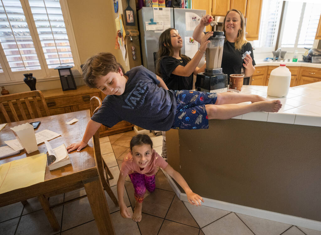 From right, Stephanie Foss makes milkshakes as a special treat for her children Ava, 12, Olivia 8, and Mateo  6, after completing their first day of Zoom classes in their Santa Rosa home on Monday,  August 17, 2020.   (Photo by John Burgess/The Press Democrat)