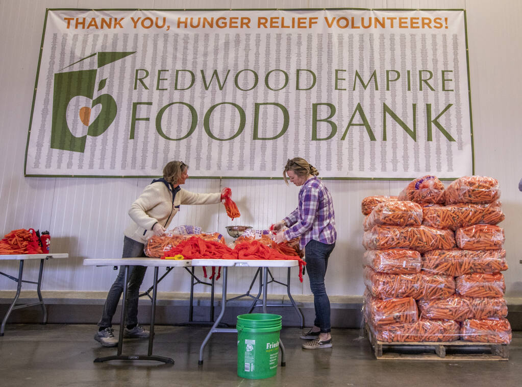 Redwood Empire Food Bank volunteers sort bags of carrots for Thanksgiving at the Santa Rosa facility Tuesday Nov. 22, 2022. Redwood Empire Food Bank, the North Bay's largest supplemental food distributor, says they have seen demand skyrocket to levels reaching the immediate start-of-pandemic levels, while supply chain issues and cost of goods remain at an all-time high. (Chad Surmick / The Press Democrat)