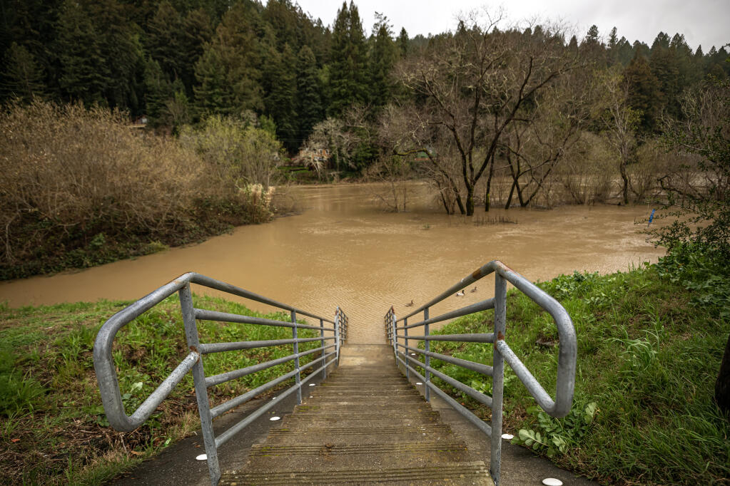 Stairs to the Monte Rio public beach disappear in the Russian River after rains left the region drenched with the latest round of storms, Monday February 19, 2024. (Chad Surmick / The Press Democrat)