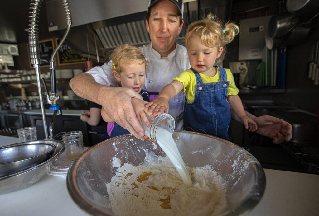 Estero Cafe owner and chef Ryan Ramey mixes up pancakes along with the help of his two daughters, Ivy, 4, left, and Danny, 2, at the Estero Cafe in Valley Ford on June 7, 2022. (Chad Surmick / The Press Democrat)