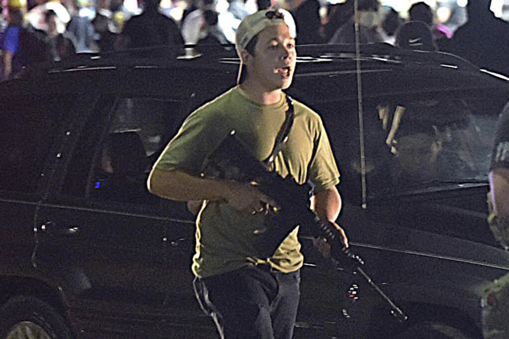 FILE - Kyle Rittenhouse walks along Sheridan Road in Kenosha, Wis., in this Aug. 25, 2020 file photo. A Wisconsin judge on Friday, Jan. 28, 2022, approved an agreement by lawyers to destroy the assault-style rifle that Rittenhouse used to shoot three people during a 2020 street protest.  (Adam Rogan/The Journal Times via AP, File)