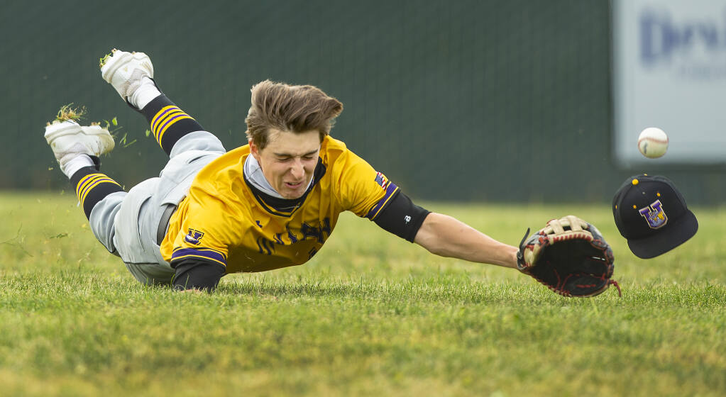 Ukiah’s Ethan Rinehart’s hat flew off his head while diving for a pop-up to left field. Two runs scored as the ball went past Rinehart and Maria Carrillo went on to beat Ukiah, 7-1, on Friday, April 23, 2021. (Photo by John Burgess/The Press Democrat)
