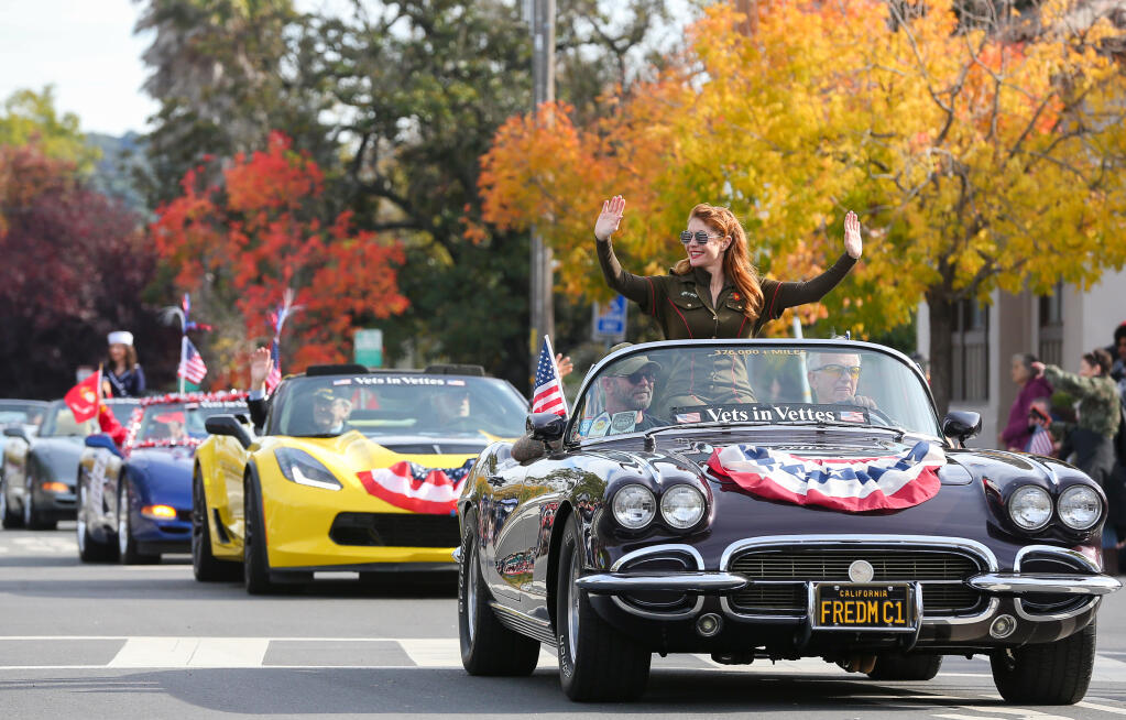 Janet Desena, riding with the Vets in Vettes entry, waves to the crowd during the Veterans Day Parade in Petaluma on Friday, November 11, 2022.  (Christopher Chung/The Press Democrat)