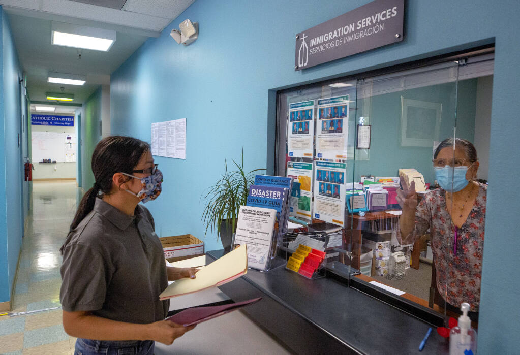 A DACA recipient named Adriana, who declined to provide her last name, asks for information from office coordinator Isabel Ladd-Larsen, right, about procedures to renew her DACA status, at Catholic Charities in Santa Rosa, California, on Tuesday, September 15, 2020. (Alvin A.H. Jornada / The Press Democrat)