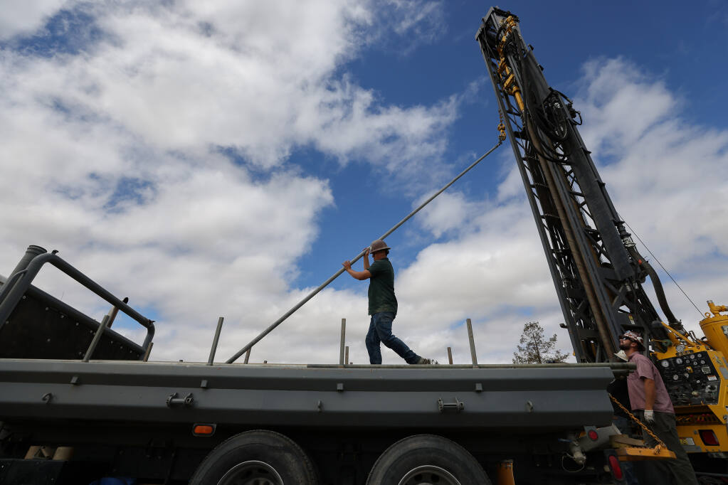 Rafael Barreto Guerrero, of Weeks Drilling & Pump Co., helps move a pipe into place for a well on a vineyard property near Sonoma on Tuesday, June 22, 2021. (Christopher Chung/ The Press Democrat)