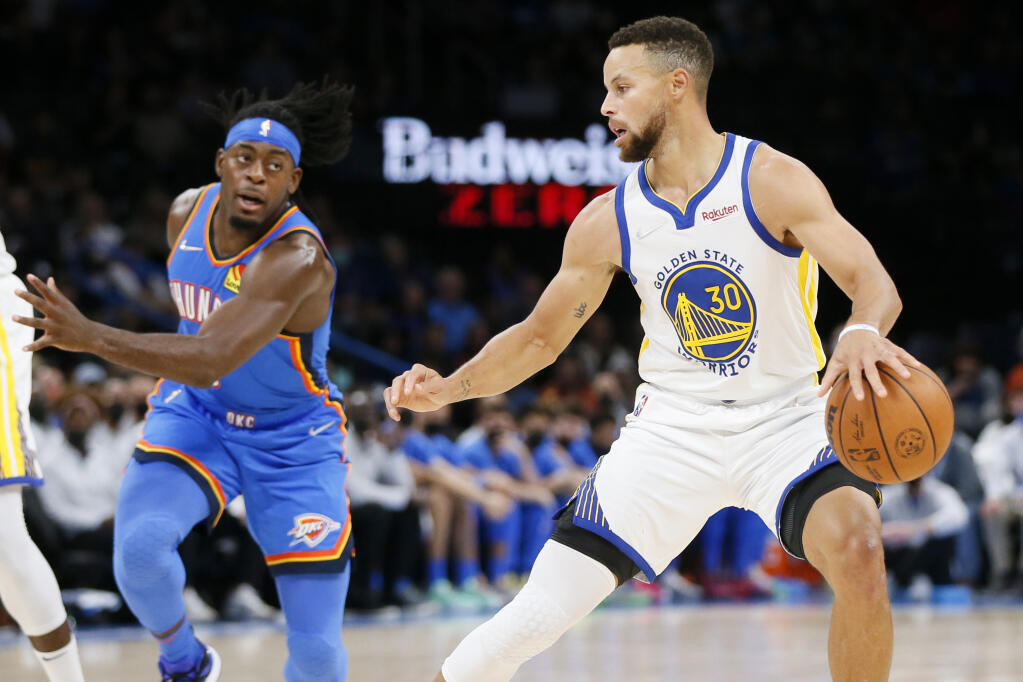 Golden State Warriors guard Stephen Curry (30) dribbles near Oklahoma City Thunder forward Luguentz Dort, left, in the first half of an NBA basketball game Tuesday, Oct. 26, 2021, in Oklahoma City. (AP Photo/Nate Billings)
