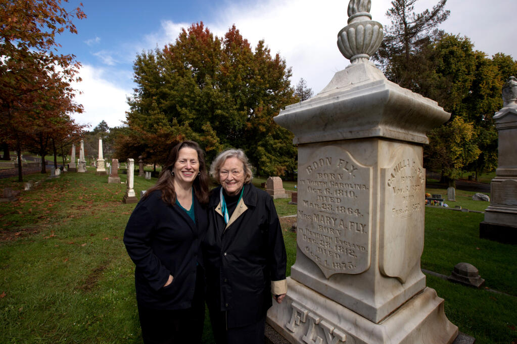 Rebecca Yerger, Napa County Landmark's board member, left, and Nancy Brennan, the cemetery's honorary historian, stand near one of many historic tombstones at Tulocay Cemetery in Napa on Tuesday, Nov. 1, 2022.  (Darryl Bush / For The Press Democrat)