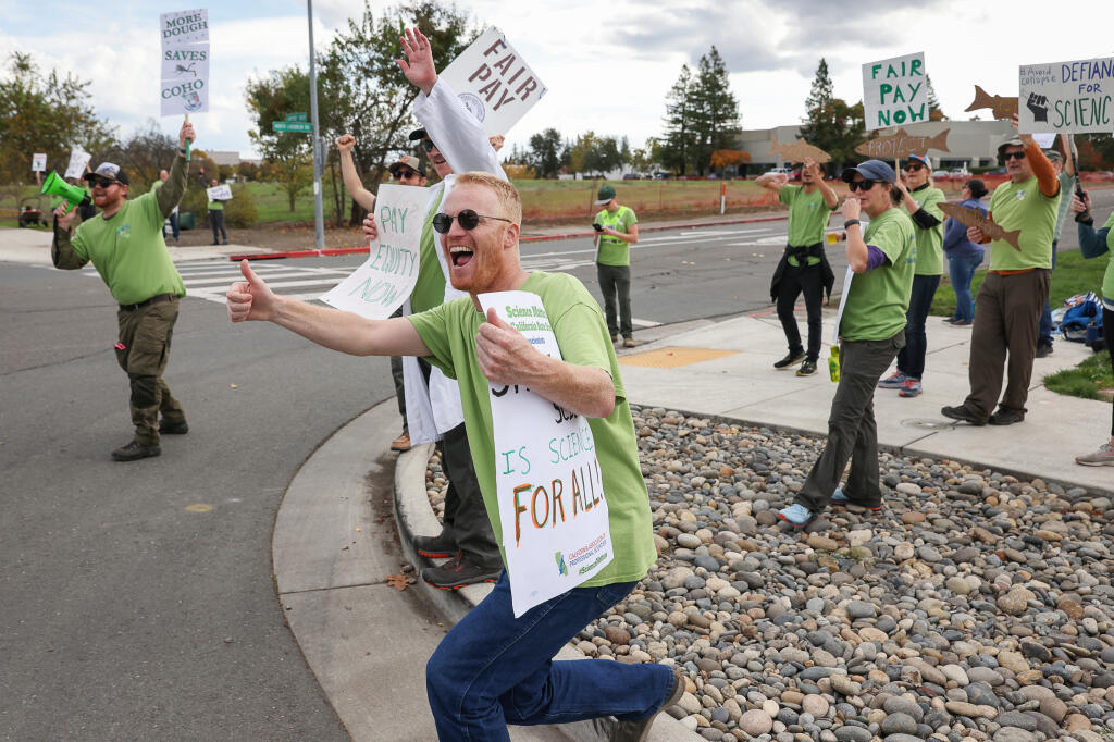 Aidan Ward, an environmental scientist with the California Department of Food and Agriculture, pickets with fellow scientists from the California Department of Fish and Wildlife, on the corner of Airport Boulevard and North Laughlin Road, in Santa Rosa on Friday, November 17, 2023.  (Christopher Chung/The Press Democrat)