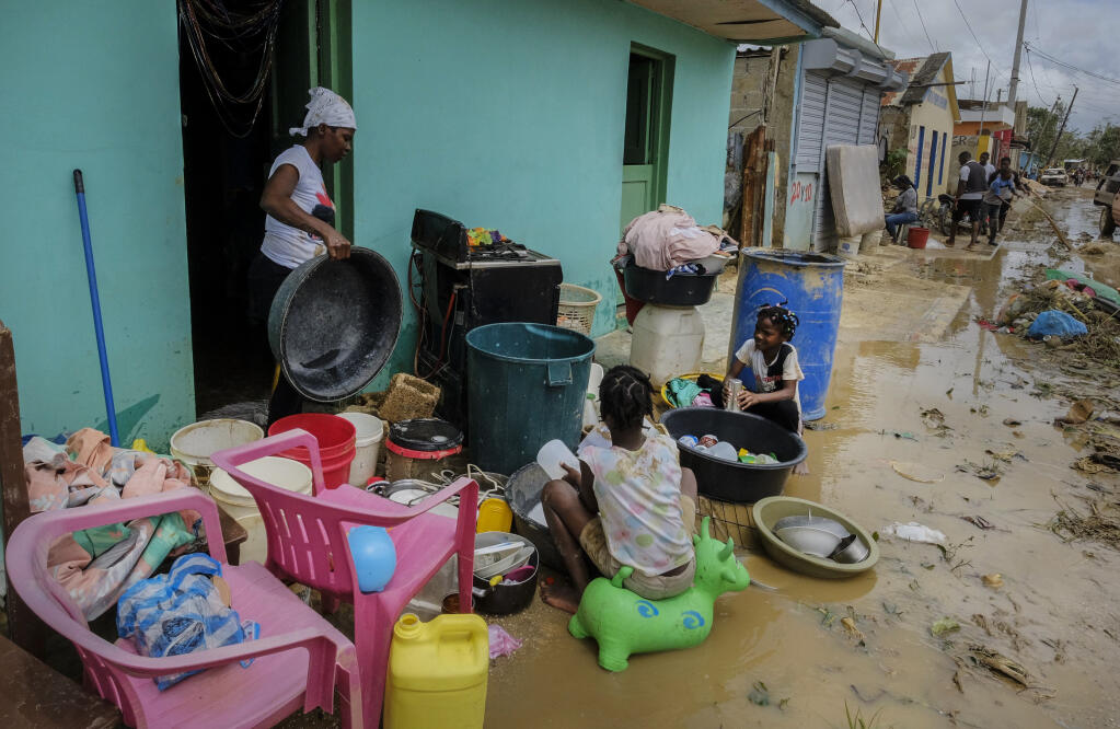 Neighbors work to recover their belongings from the flooding caused by Hurricane Fiona in the Los Sotos neighborhood of Higüey, Dominican Republic, Tuesday, Sept. 20, 2022. (AP Photo/Ricardo Hernandez)