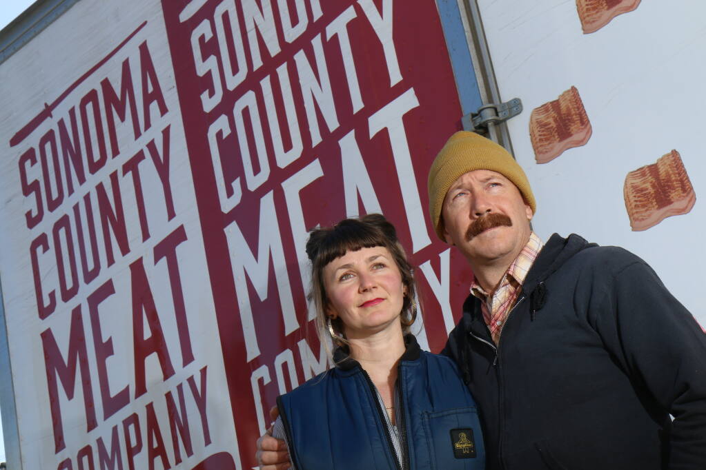 Jenine and Rian Rinn, owners of Sonoma County Meat Co., pose in front of one of the delivery vans parked at the original location at 35 Sebastopol Ave., Santa Rosa, on Tuesday, Feb. 22, 2022. (Jeff Quackenbush / North Bay Business Journal)