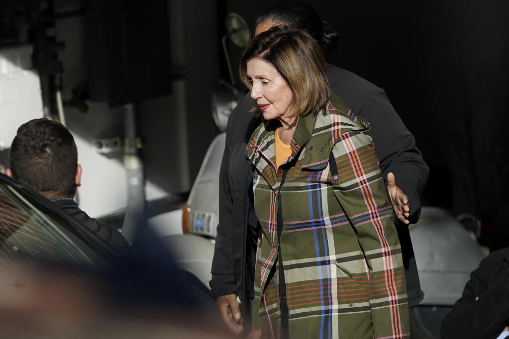 House Speaker Nancy Pelosi is escorted to a vehicle outside of her and husband Paul Pelosi's home in San Francisco, Wednesday, Nov. 2, 2022. (AP Photo/Jeff Chiu)
