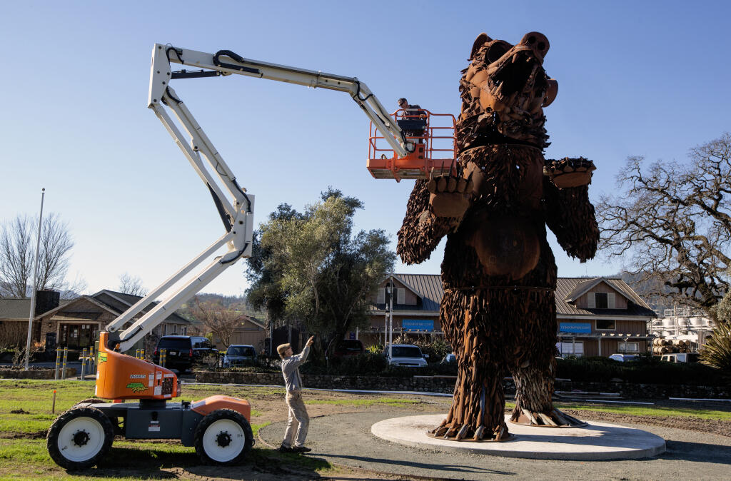 Sculptor Bryan Tedrick signals to Adam Moody, in the bucket, during the final phase of the installation of the metal bear sculpture in front of St. Anne’s Crossing Winery on Highway 12 in Kenwood on Monday, Jan. 24, 2022. (Robbi Pengelly/Index-Tribune)