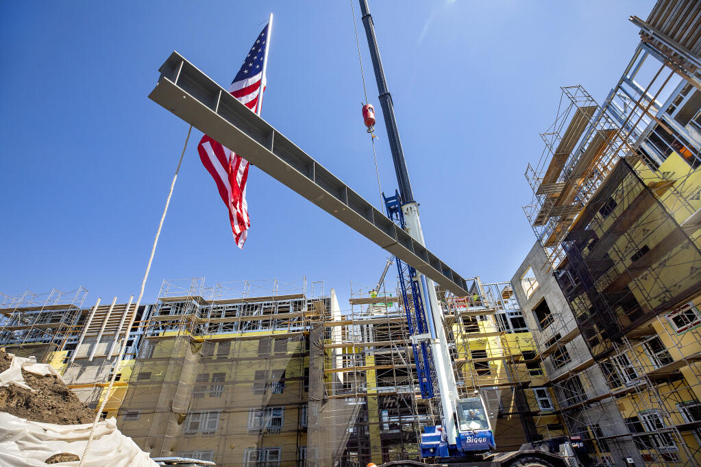 The final structural beam is raised into place on the new five-story, 352-bed residence hall at Santa Rosa Junior College August 25, 2022.    (John Burgess/The Press Democrat)
