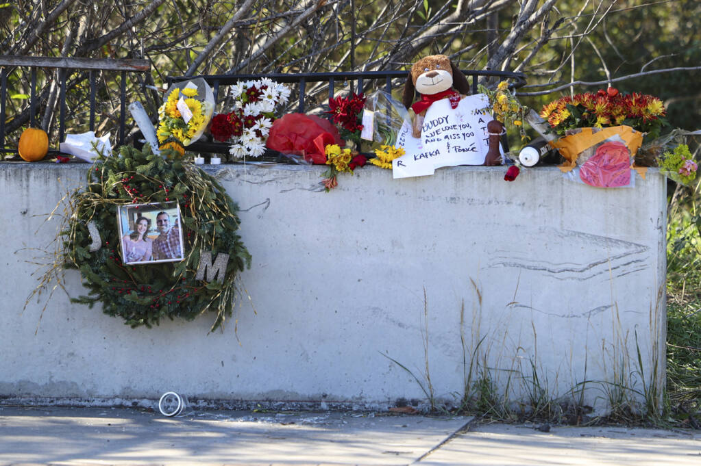 A memorial for Matthew Chachere, 39, and Jennifer Besser, 36, who were found dead under dense brush is seen in San Luis Obispo, Calif., Tuesday, Nov. 29, 2022. Authorities say a California couple and their dog who were all found dead in a creek bed last week were likely hit by a speeding car and police have interviewed the driver. San Luis Obispo police say the bodies were discovered under dense brush on Nov. 22, 2022, after officials received a report of a dead dog in the area. (David Middlecamp/The Tribune via AP)