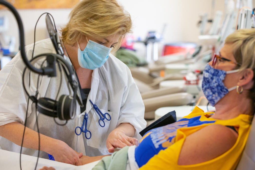 Head nurse Paula Robinson checks Thea Daniels' arm before inserting a needle for a donation during a blood drive at Vitalant in Santa Rosa, California, on Saturday, Aug. 29, 2020. (Alvin A.H. Jornada / The Press Democrat)