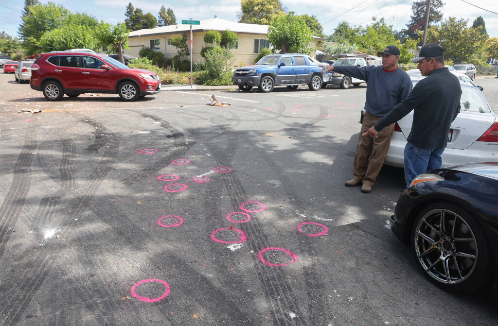 Residents look over the scene where a shooting left one person dead and three others injured at the intersection of Beachwood and Greenwood Drive, in Santa Rosa on Monday, July 5, 2021.  (Christopher Chung/ The Press Democrat)