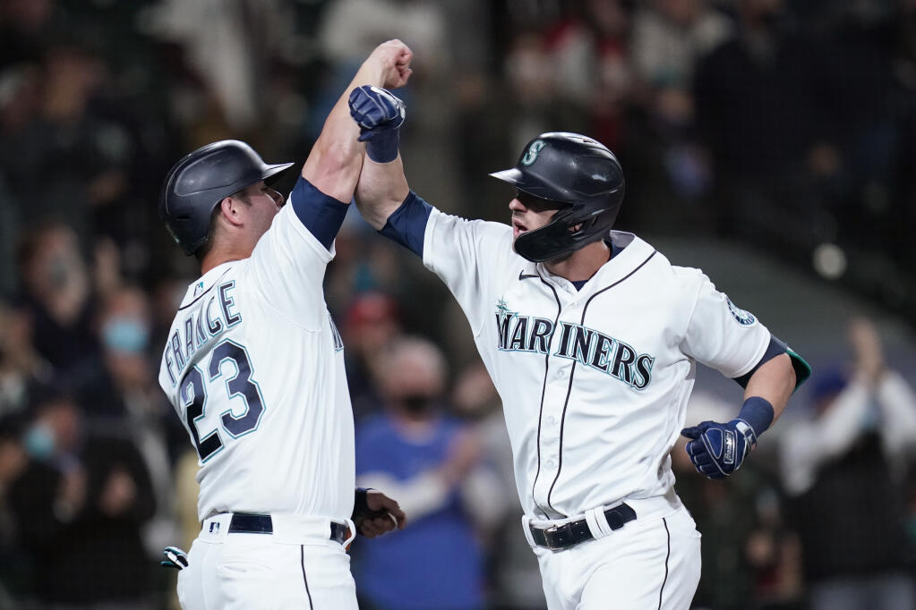 Seattle Mariners' Mitch Haniger, right, is greeted by Ty France (23) after hitting a three-run home run against the Oakland Athletics in the fourth inning of a baseball game Monday, Sept. 27, 2021, in Seattle. (AP Photo/Elaine Thompson)