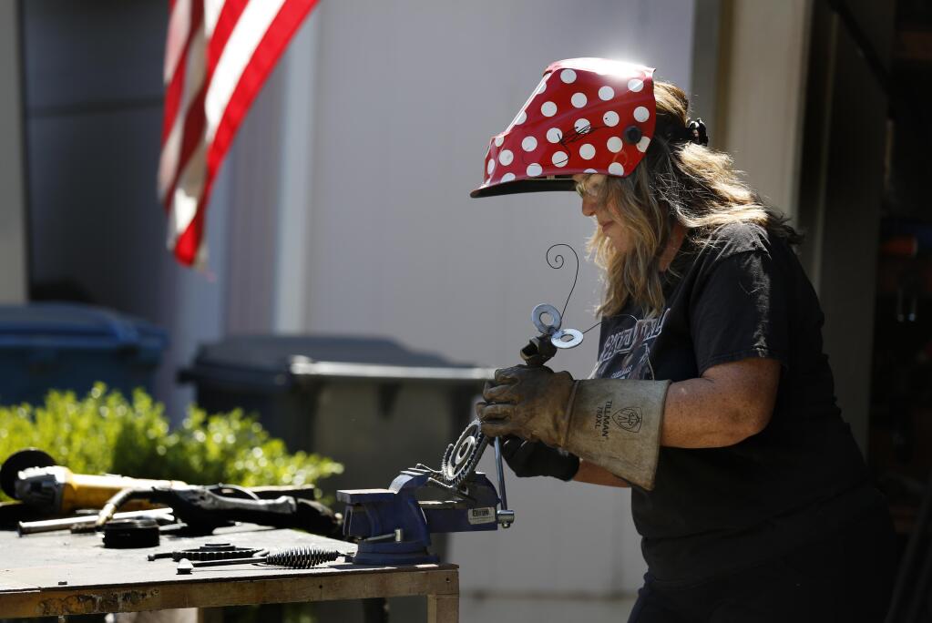 Erin Baker the "Polkadot Welder’“ works on making a snail sculpture out of old metal parts at her home in Rohnert Park on Wednesday, July 15, 2020. (Beth Schlanker / The Press Democrat)