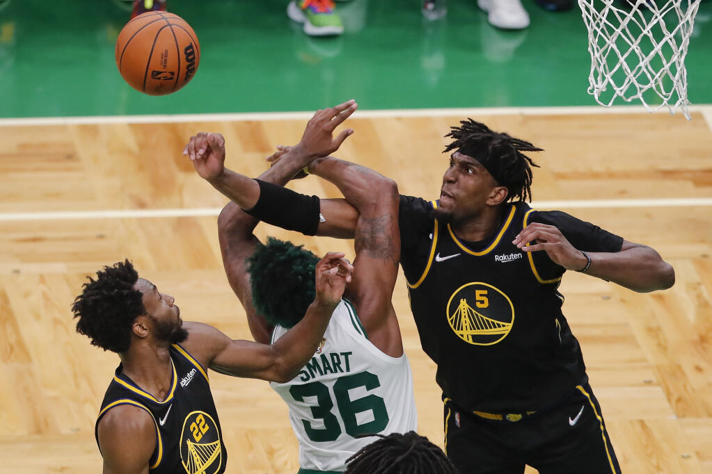 Warriors center Kevon Looney, right, fights for a rebound against Celtics guard Marcus Smart during the fourth quarter of Game 4 of the NBA Finals on Friday, June 10, 2022, in Boston. (Michael Dwyer / ASSOCIATED PRESS)