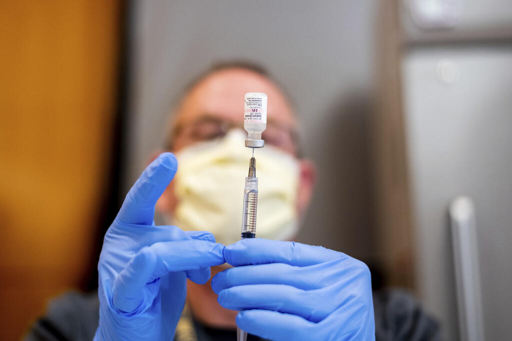 A pharmacist draws saline while preparing a dose of Pfizer's COVID-19 vaccine On Jan. 12, 2021, in Sacramento. (Noah Berger, / Associated Press)
