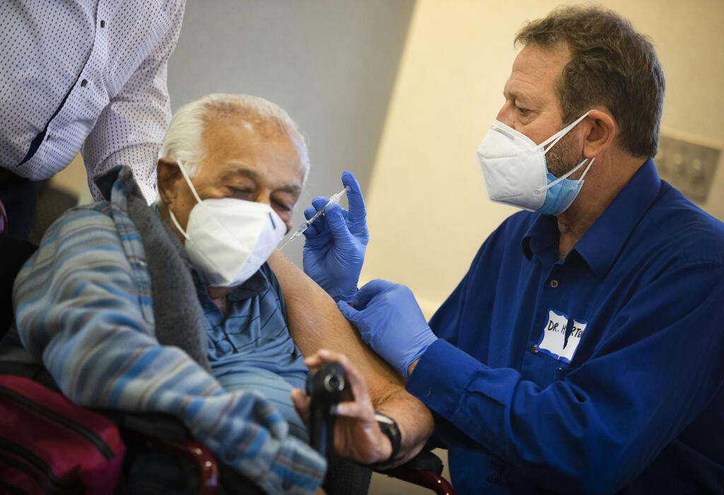 Dr. Steve Mertens injects Vinodehanora Mehta with his second dose of the Pfizer COVID-19 vaccine at the Sonoma County Public Health lab on Friday, Jan. 29, 2021.  (John Burgess/The Press Democrat)
