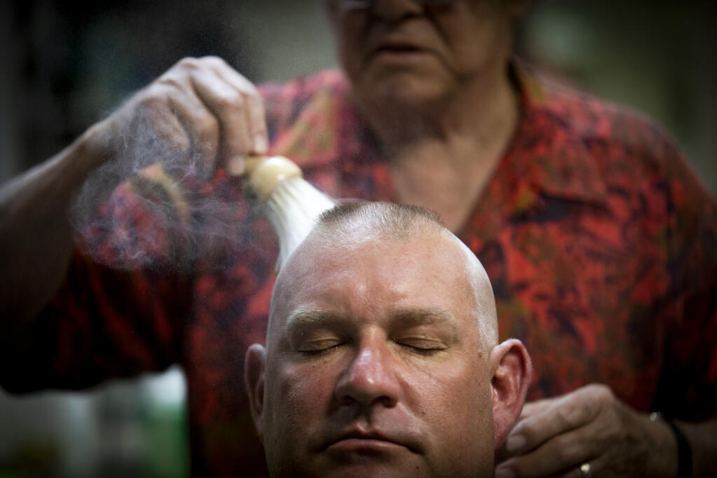 After finishing a shave, barber Rick Vitali, 82, applies a dusting of old-fashioned Clubman powder on customer Mike Granger, 30, at Vitali Barber Stylist shop in Santa Rosa on Dec. 3, 2021. (John Burgess/The Press Democrat)